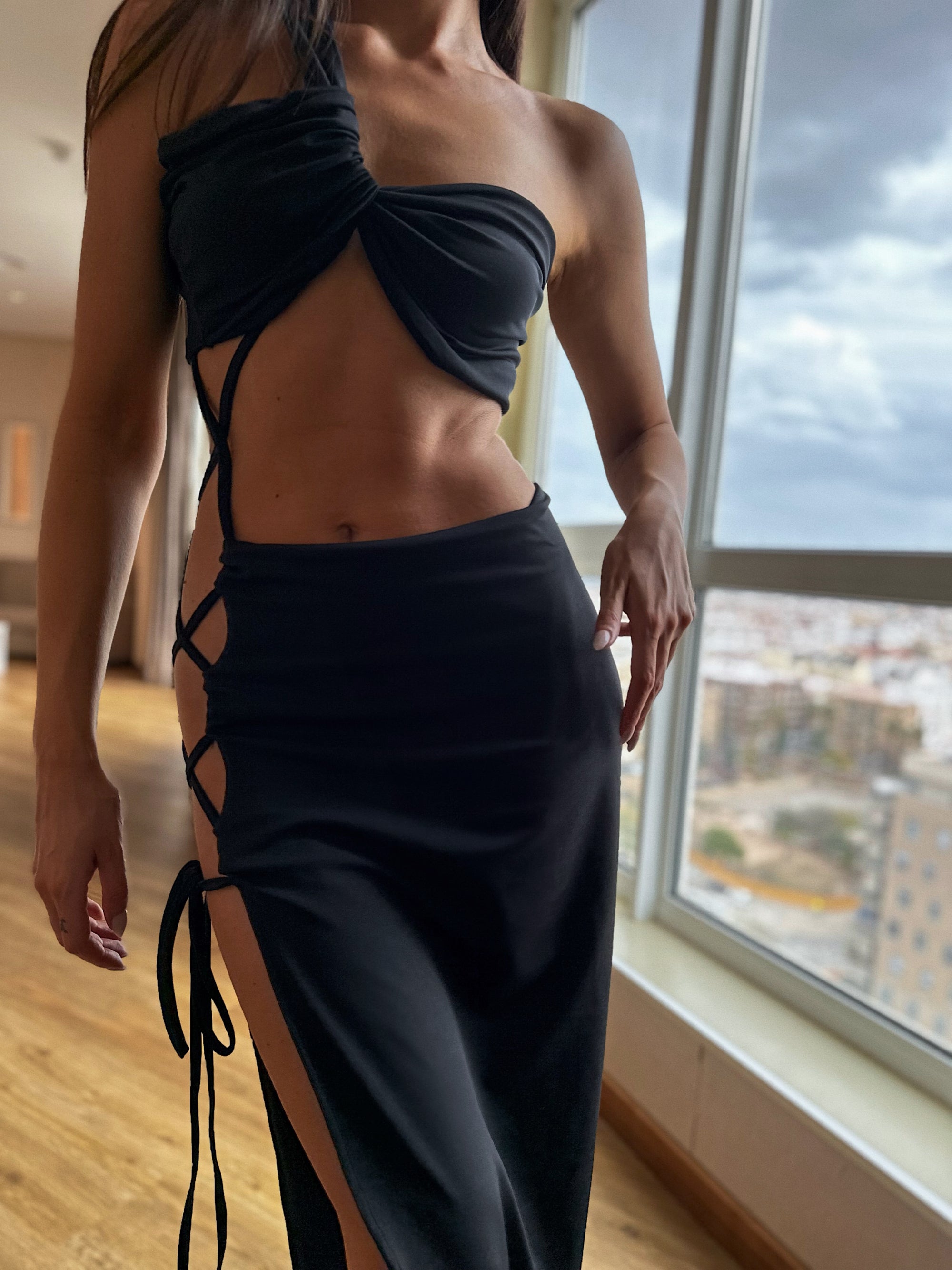 Close up of a females body wearing a black dress